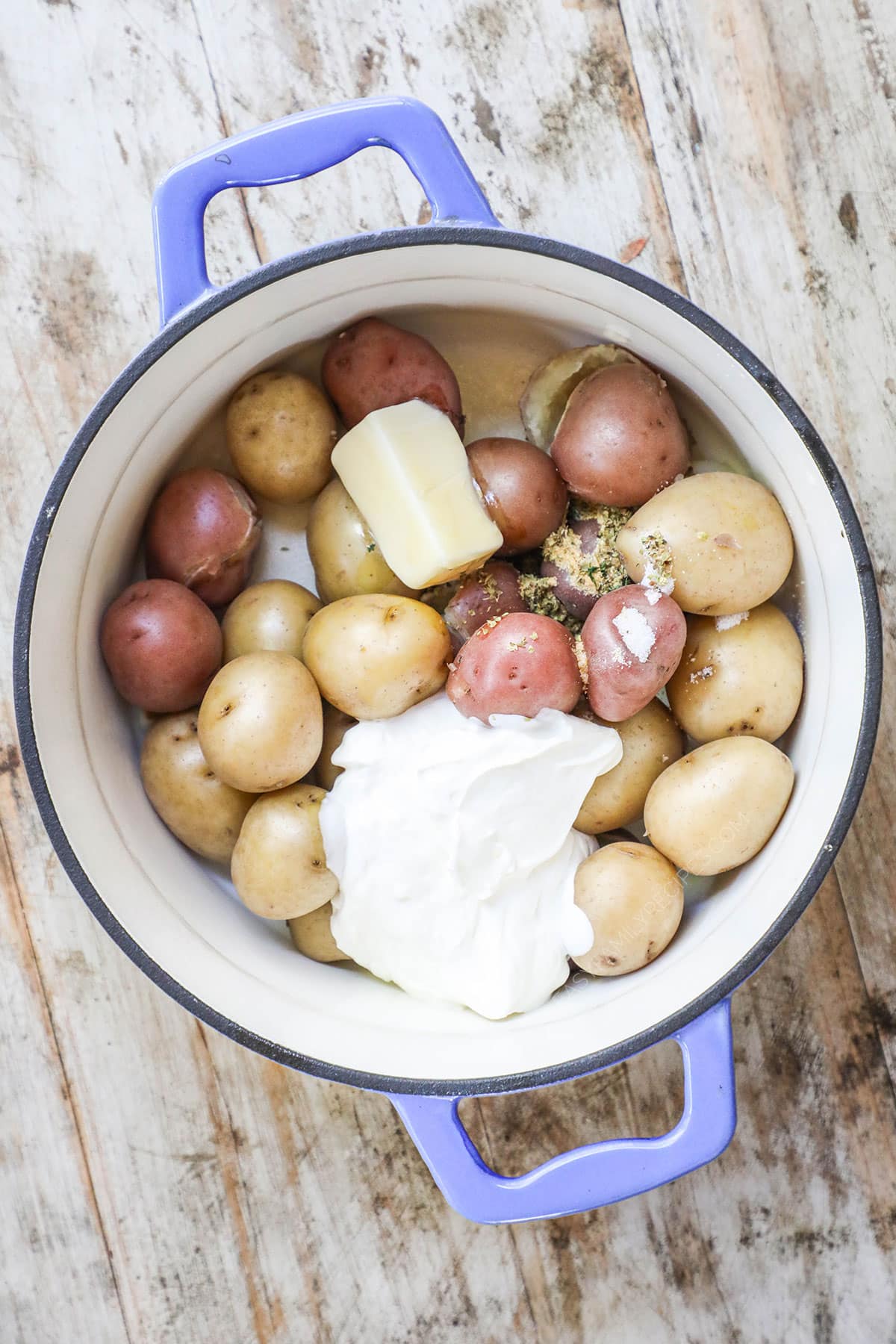 Drain water. Add the butter, sour cream, oregano, salt and garlic powder to the potatoes