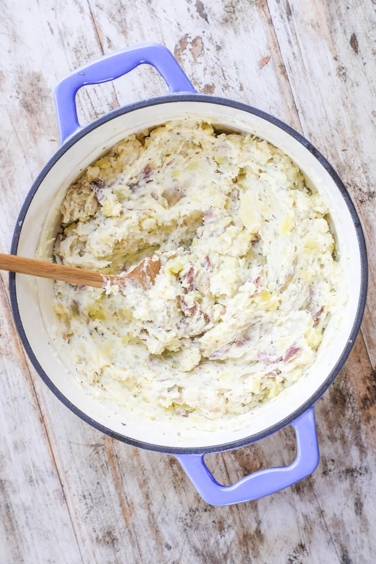 Mash potatoes with a potato masher