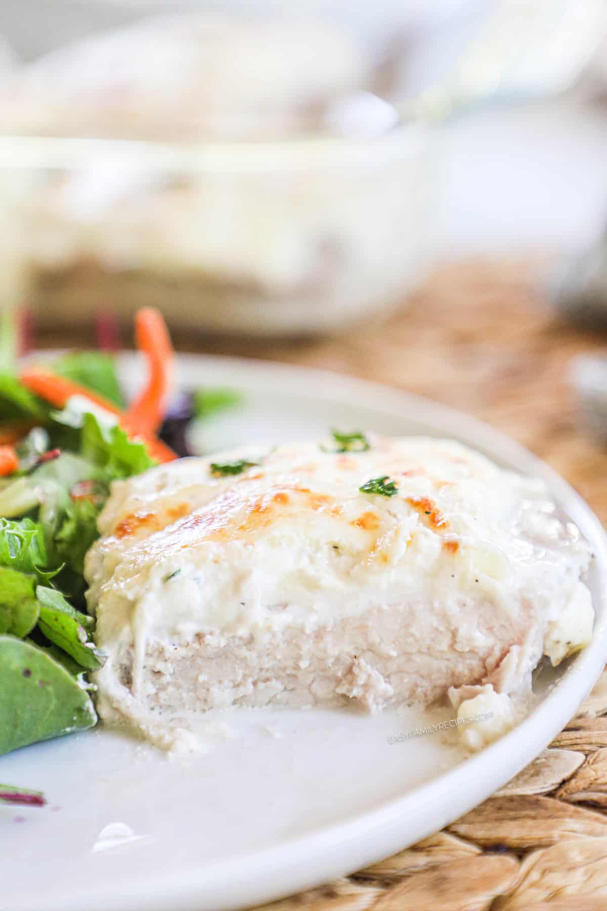 Boneless pork chop on a plate with garlic cream sauce.