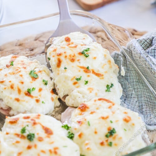 Baked pork chops with garlic cheese topping in a baking dish.