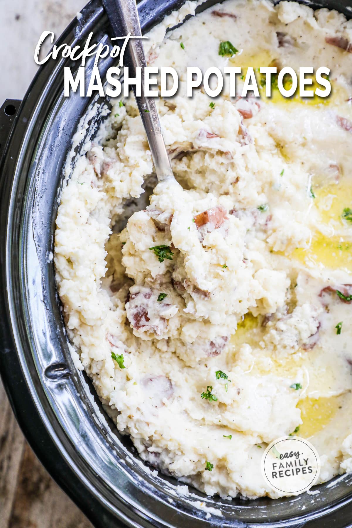 overhead of garlic mashed potatoes in a slow cooker with a spoon.