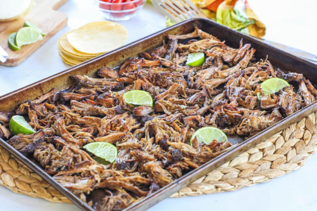 Crockpot Pork Carnitas recipe prepared and spread on a sheet pan to crisp.