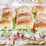 Italian grinder sliders layered with cheese, deli meat, and a dressed shredded salad with crisp top buns.