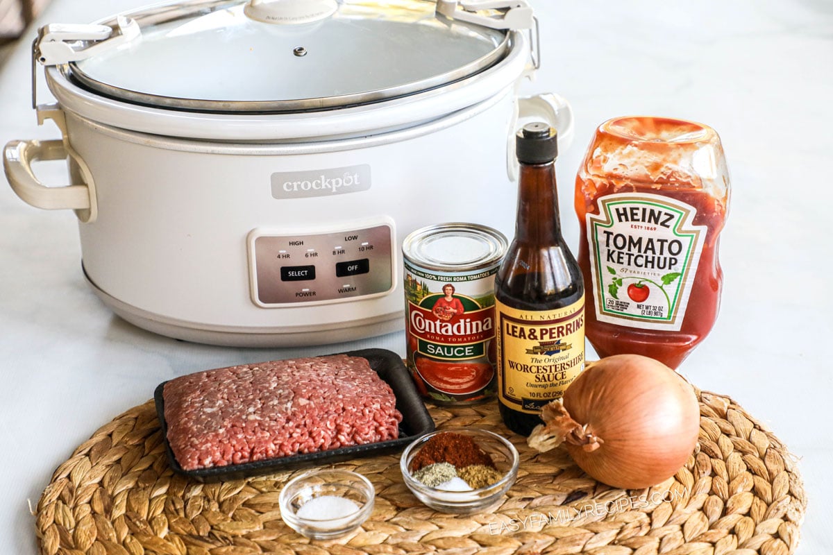 ingredients to make hot dog chili in a Crock Pot including ground beef, ketchup, tomato sauce, onion, and seasonings.