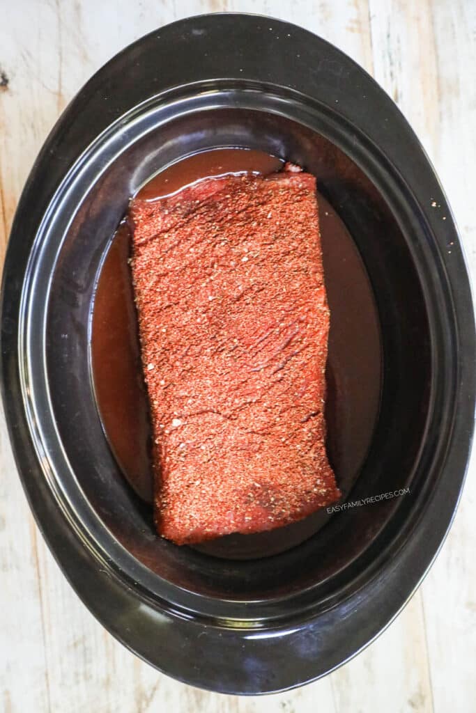 Step 3 for BBQ Brisket - Lay the brisket on top of the BBQ sauce.