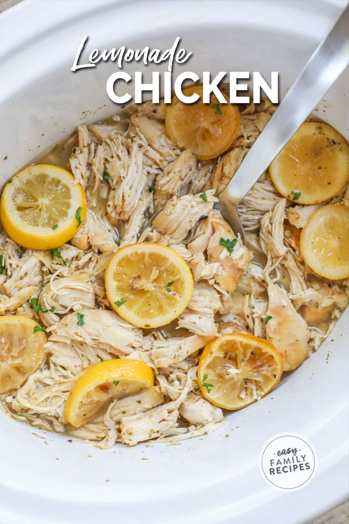 Overhead view of lemonade chicken in crockpot with serving spoon