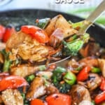 Close up of chicken and vegetables coated in stir fry sauce.