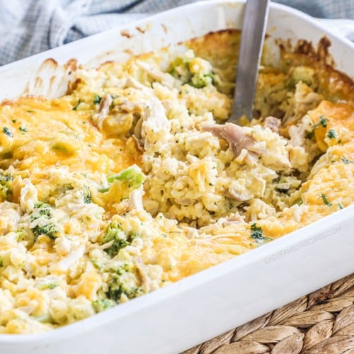 Broccoli chicken and rice casserole in a baking dish with a spoon dipped in.
