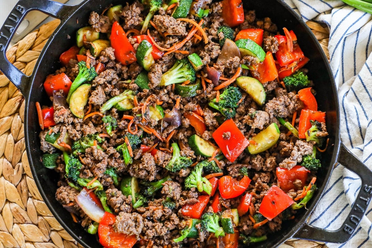 Overhead view of pan of ground beef stir fry with zucchini, peppers, and broccoli.
