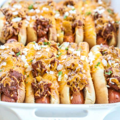 Baked chili cheese dogs in baking dish with toppings