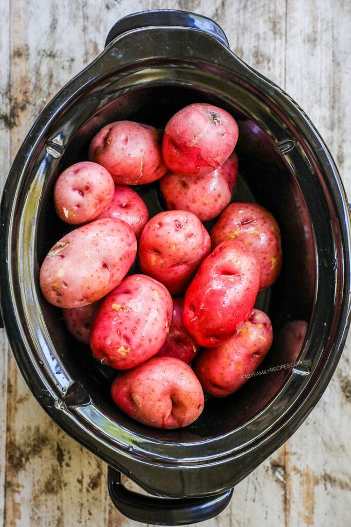 Step 1: Wash the potatoes and add with skin to a large crock pot. Add garlic cloves (whole) and chicken broth. Cook on high for 3-4 hours, or low for 4-5 hours, or until fork tender.