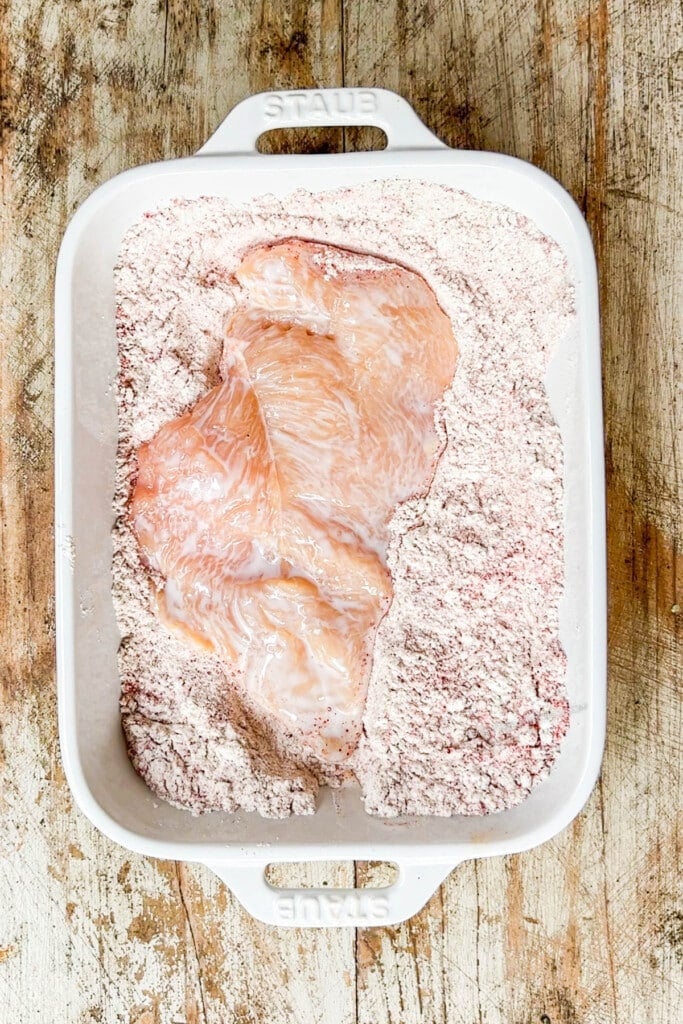 How to make Hot Honey Chicken Breast Step 2: Dredge the chicken in seasoned flour mixture.