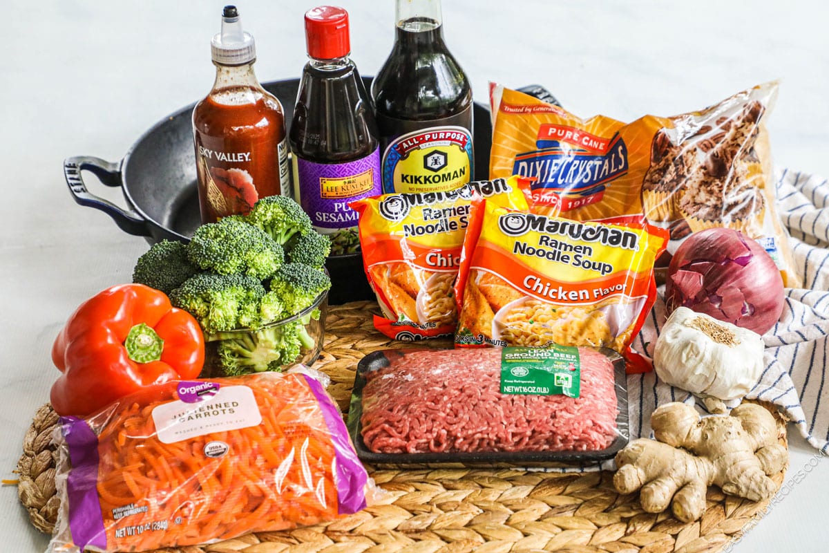 Ingredients for making a beef noodle stir fry including ground beef, instant ramen, vegetables, and soy sauce.
