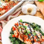 Chicken Bruschetta on a bed of spinach and a white plate. Tender Chicken with Tomatoes, garlic and basil