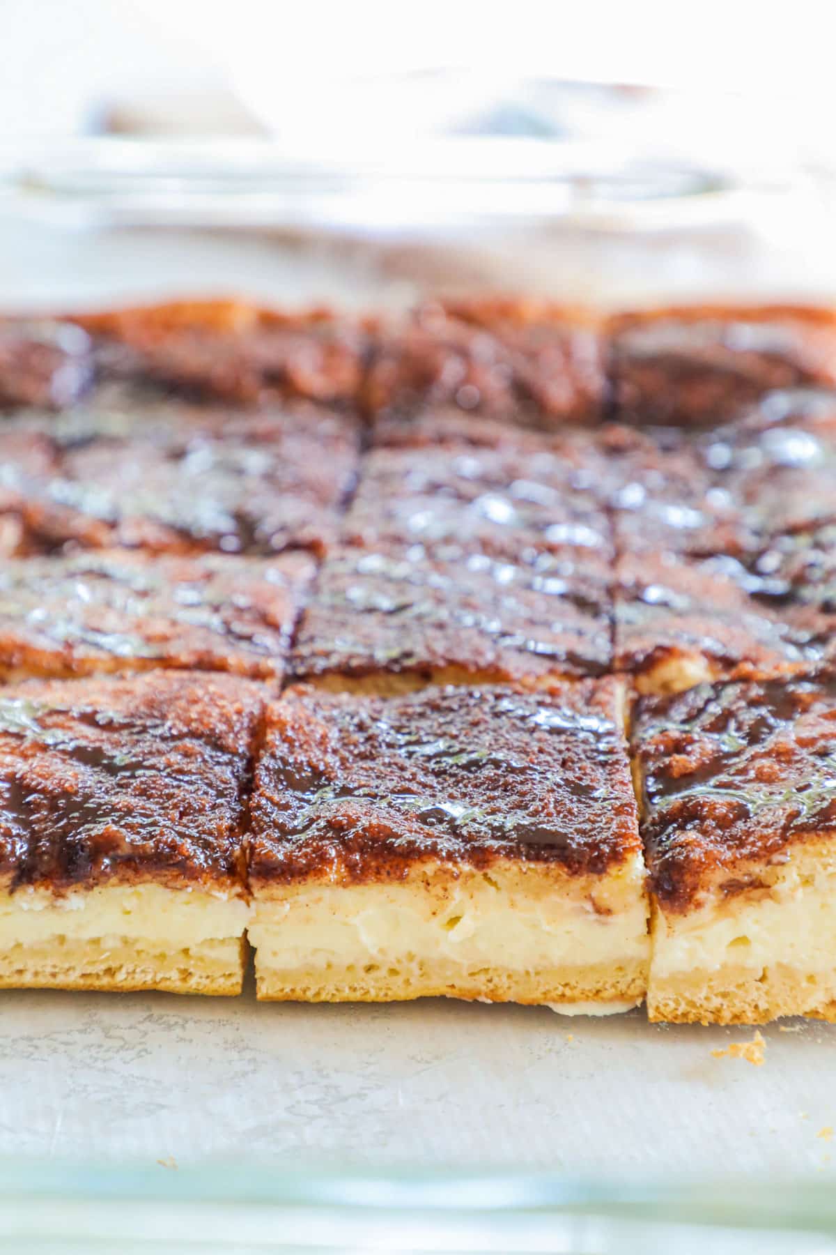 Side view of churro cheesecake bars in pan to show layers