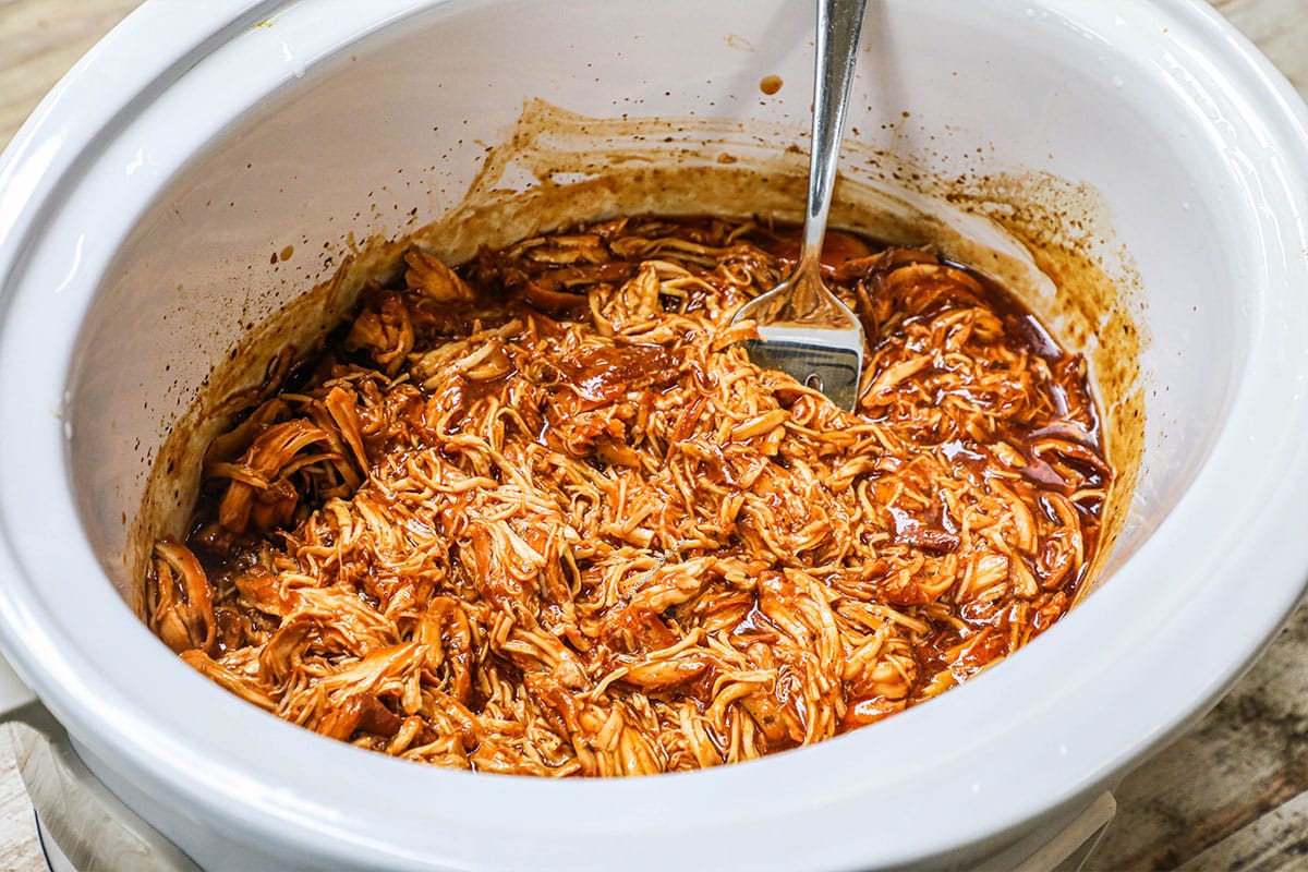 crockpot BBQ chicken in a white slow cooker