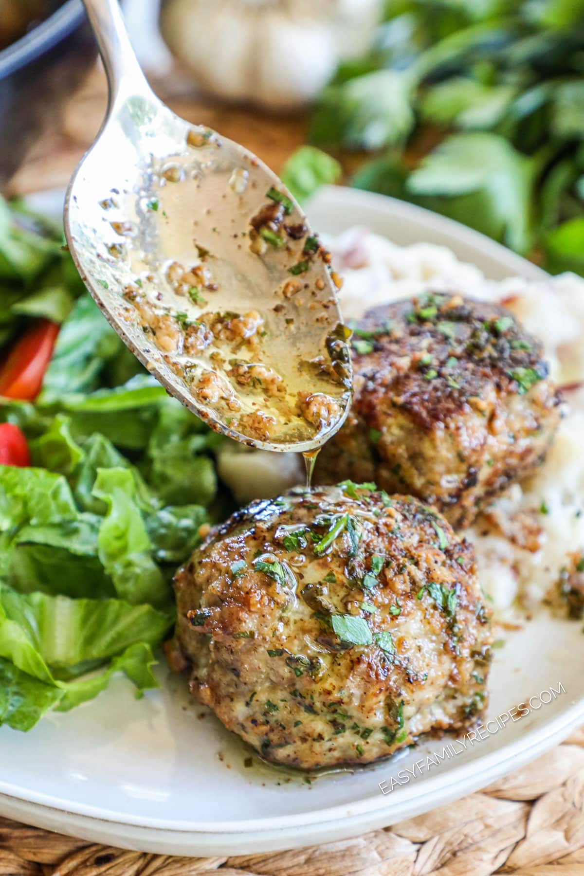 Spooning garlic butter sauce over turkey meatballs