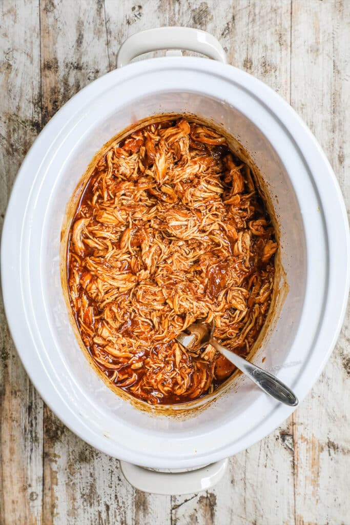 How to make crockpot BBQ Chicken step 4: Cover crockpot and cook. Once the chicken is cooked through, use forks to shred the chicken, then stir it into the BBQ sauce mixture.