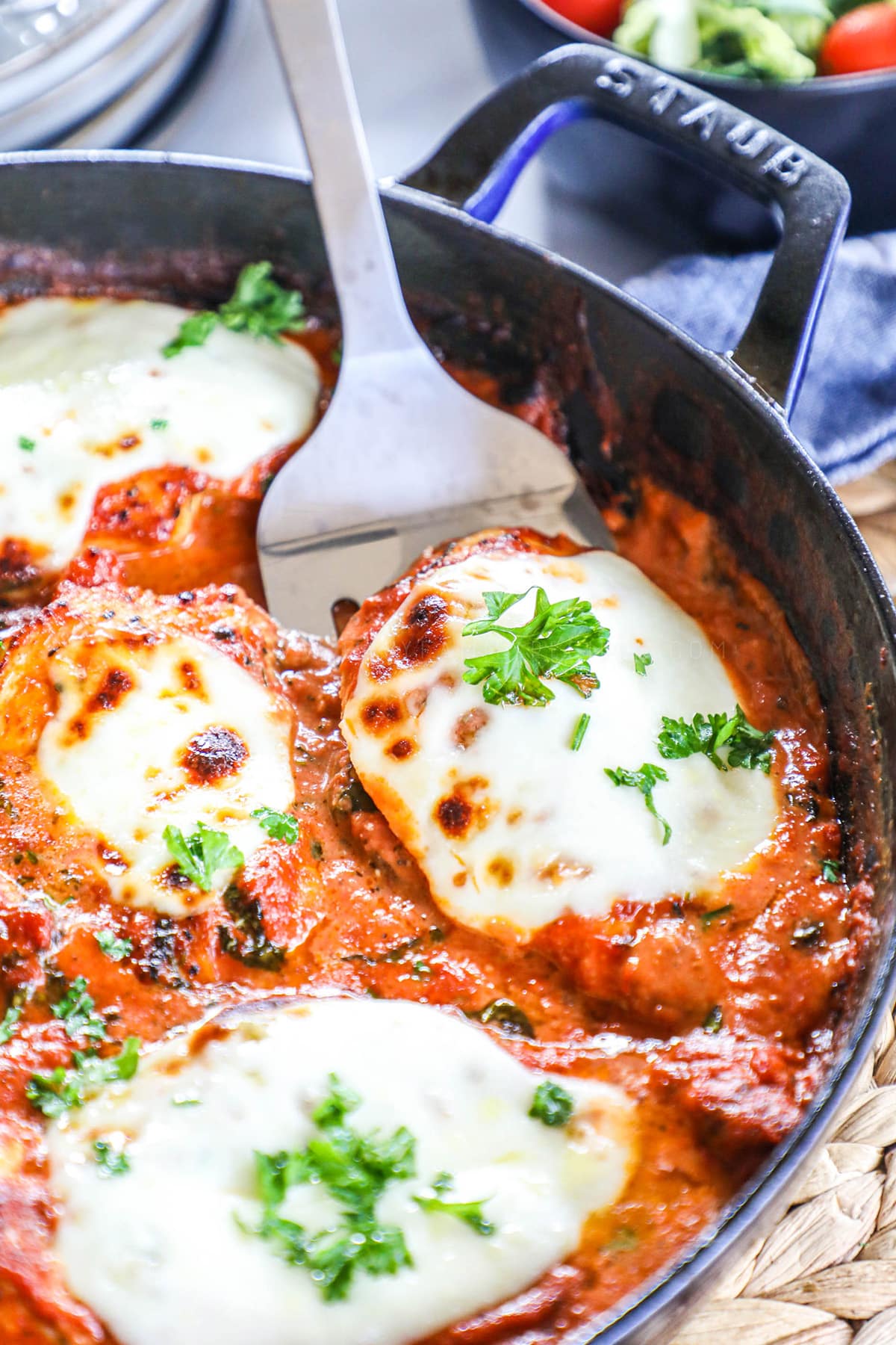 Chicken Mozzarella made in a skillet in creamy tomato sauce topped with basil.