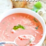 A spoonful of tomato basil soup being lifted from the bowl.