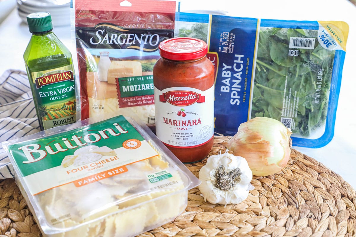 Ingredients for spinach ravioli bake: ravioli, garlic, onion, spinach, marinara, mozzarella, and olive oil