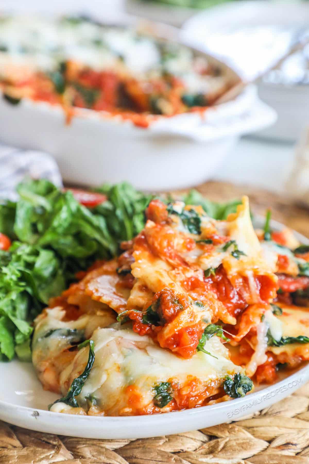 Cheesy spinach ravioli bake on plate with salad