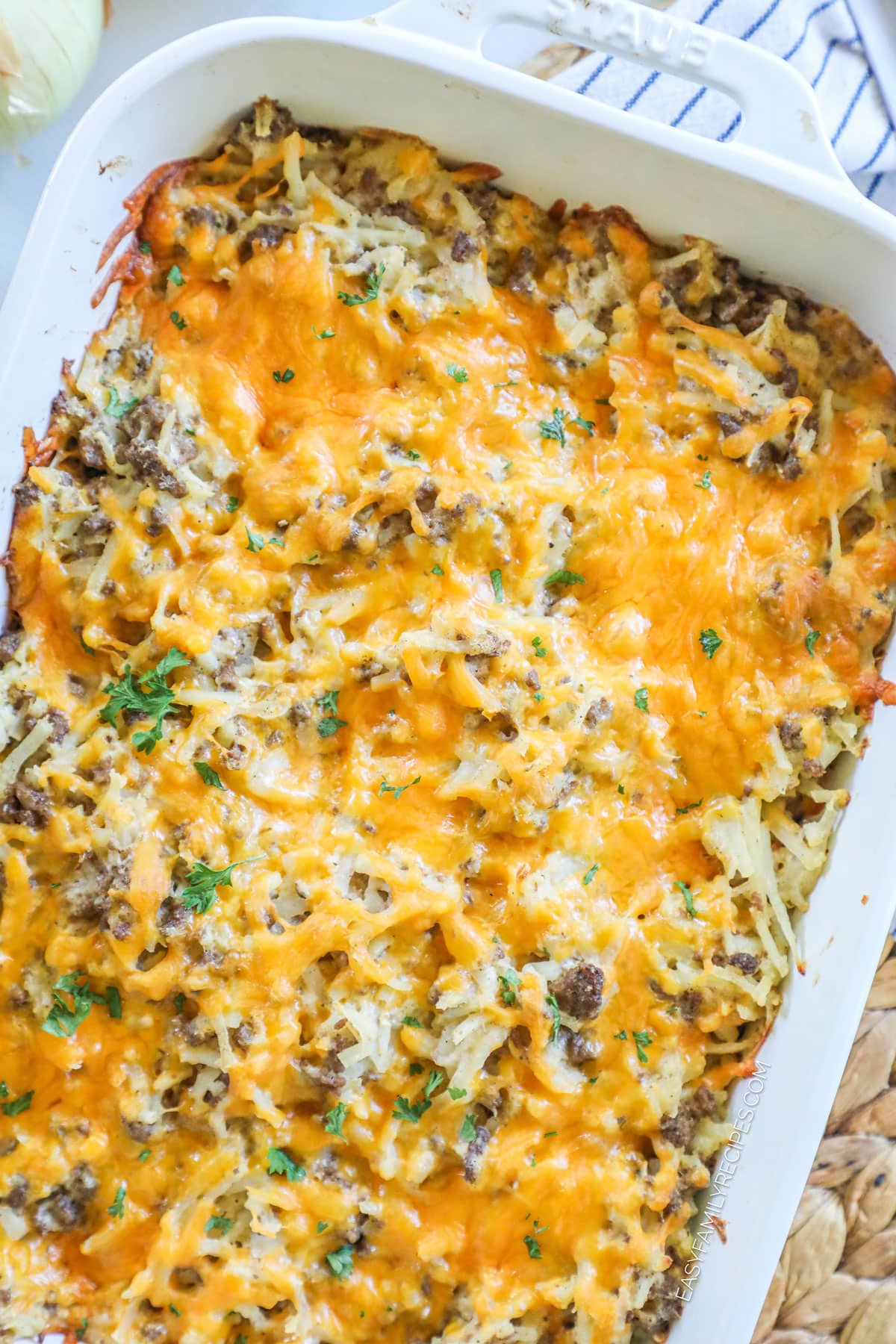 Overhead view of cheesy ground beef hashbrown casserole in baking dish