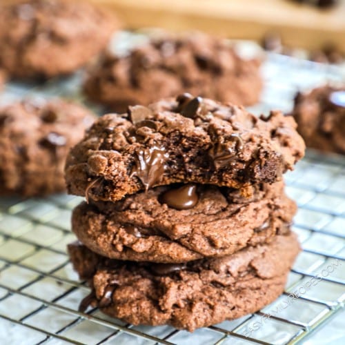 three chocolate pudding cookies stacked on a cooling rack.