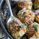 Ground Turkey Meatballs in garlic butter sauce being scooped out of a cast iron skillet.