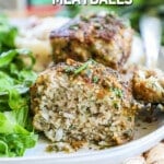 A sliced garlic butter meatball that is on a plate next to a side salad