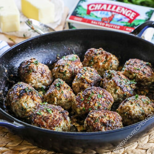 Ground Turkey Meatballs in garlic butter sauce sitting in a cast iron skillet and garnished with parsley