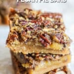 three gooey pecan pie bars stacked.
