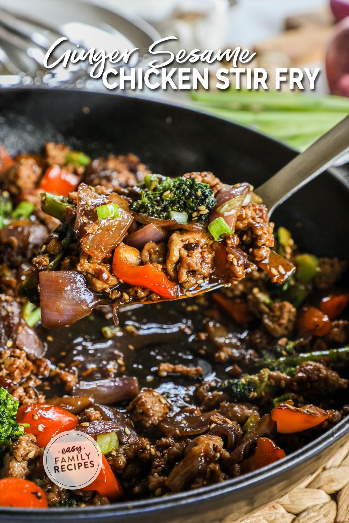 A spoon scooping ground chicken vegetable stir fry from a pan.