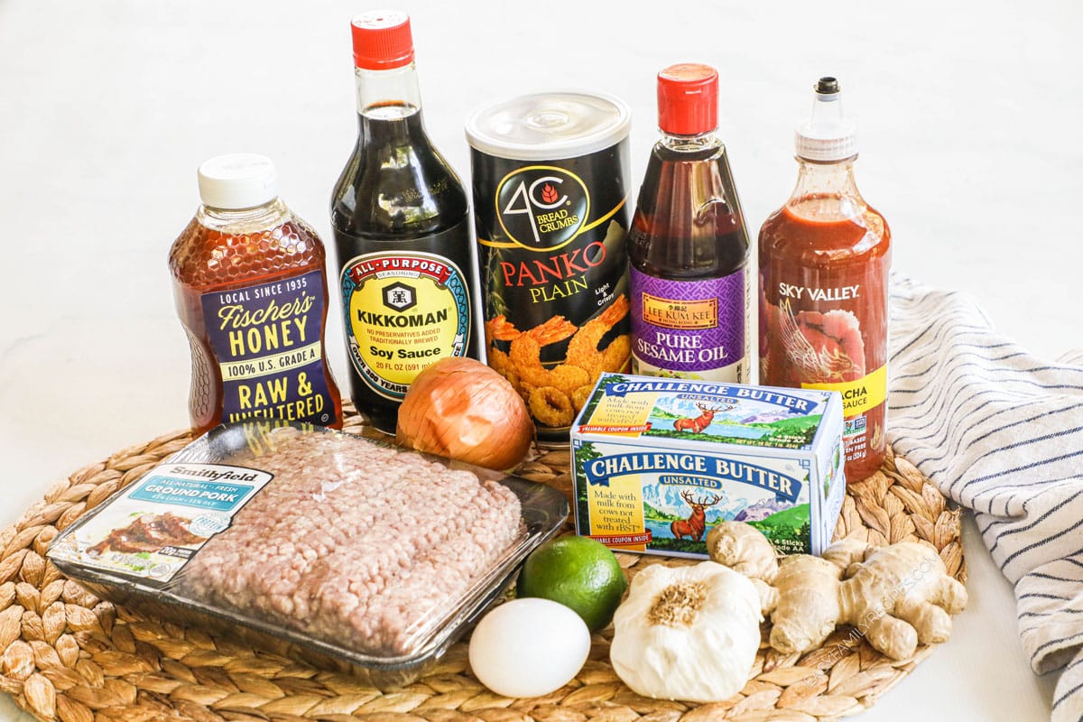 Ingredients for honey sriracha meatballs, including ground pork, egg, lime, garlic, onion, ginger, butter, sriracha, sesame oil, panko, soy sauce, honey