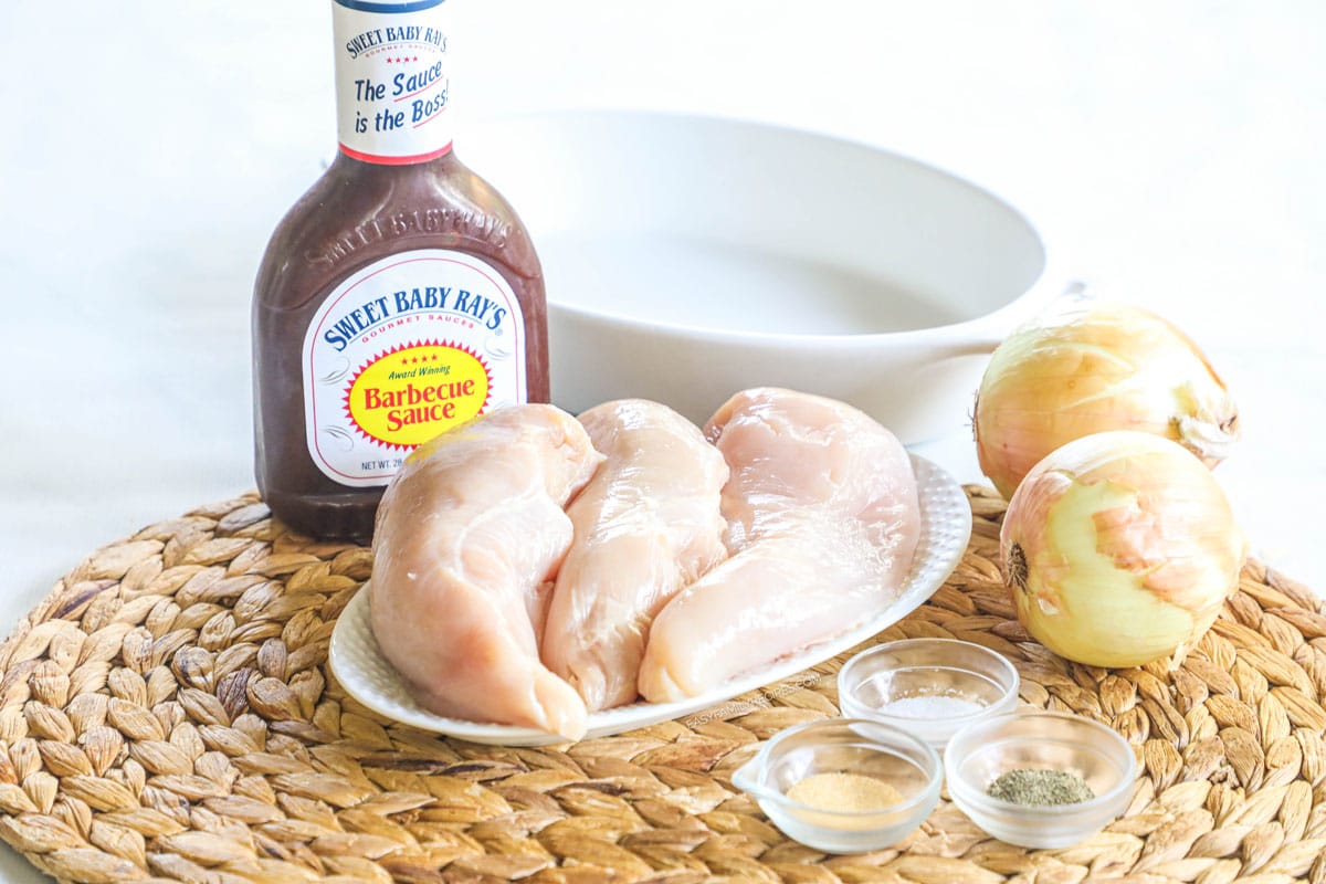 Ingredients for making a BBQ chicken bake including barbecue sauce, chicken breasts, onion, and seasoninngs.