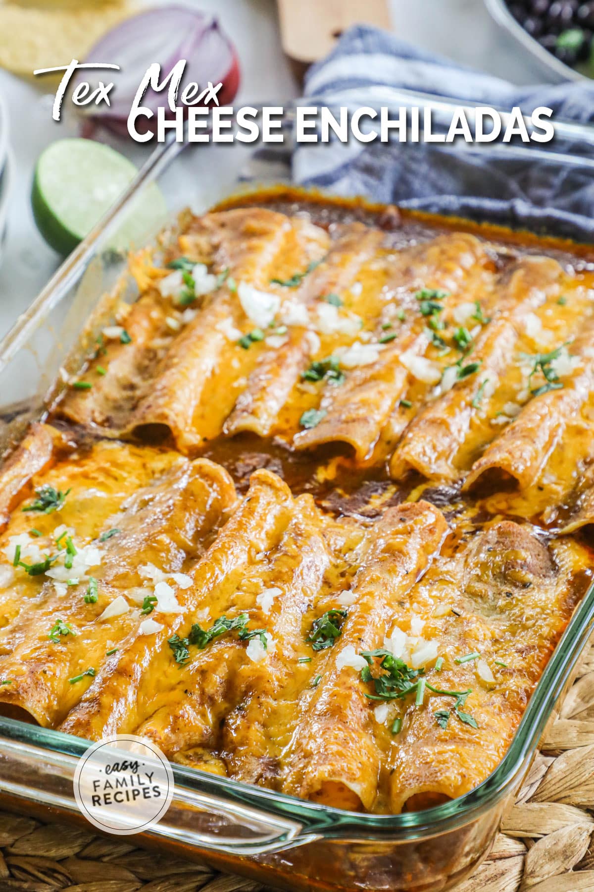 Tex Mex cheese enchiladas in a baking dish after baking to show melting cheese topping and garnish of chopped onions and cilantro.