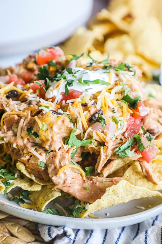 Crockpot Chicken Nachos served with cheese, sour cream, and pico de gallo