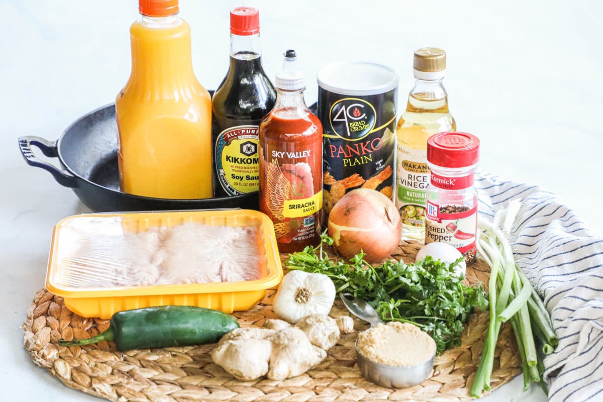 Ingredients for firecracker chicken meatballs, including sriracha, orange juice, ground chicken, cilantro, panko, onion, and more