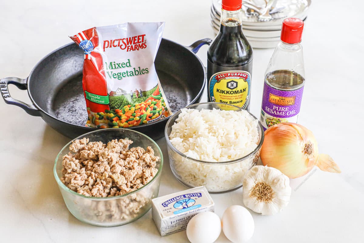 Ingredients for recipe: frozen mixed vegetables, soy sauce, sesame oil, ground turkey, rice, butter, eggs, garlic, and onion.