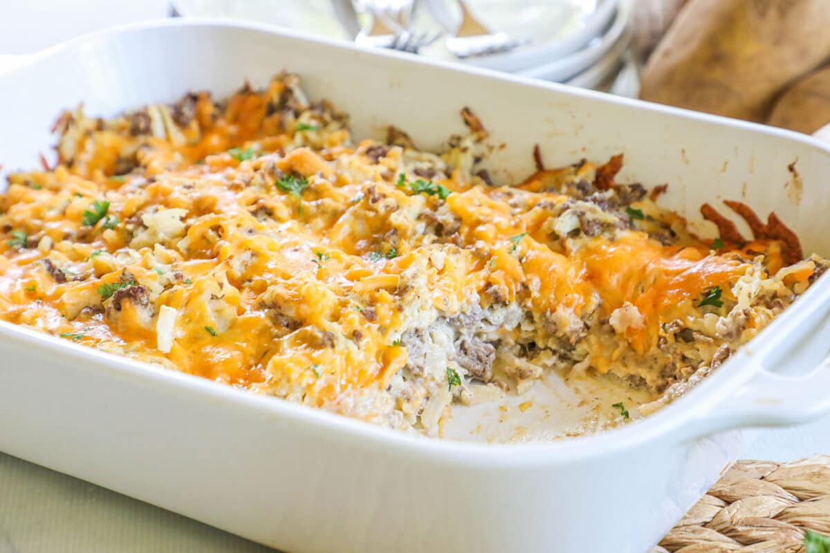 Ground beef hashbrown casserole in a white baking dish