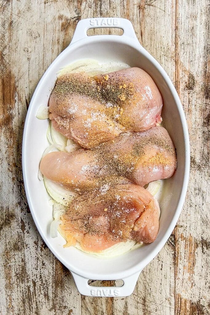 How to make BBQ Chicken in Oven Step 2: season chicen breast and place on top of onions.