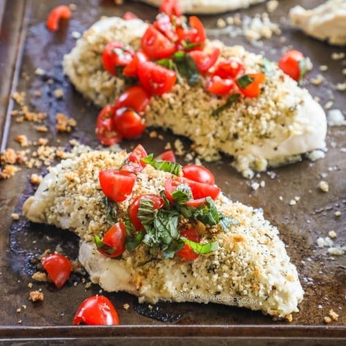 Sheet pan with baked Italian chicken topped with crispy panko, tomatoes, and basil