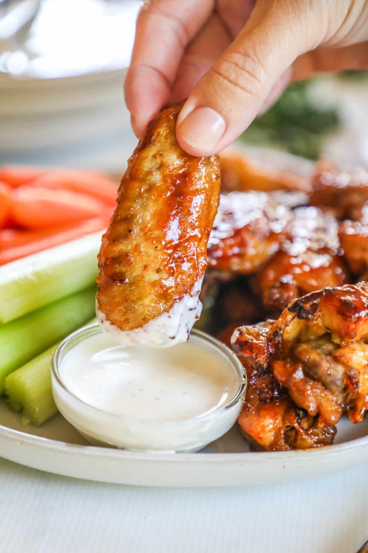 Chicken wings being dipped into ranch