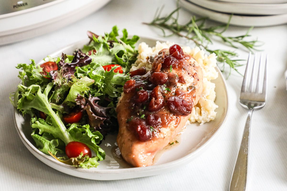 Cranberry chicken served on a plate with salad