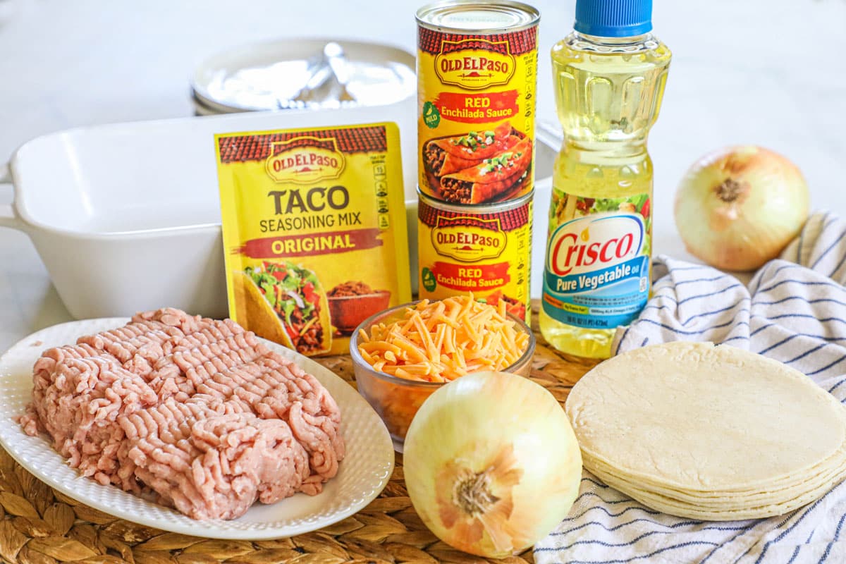 Ingredients for recipe: uncooked ground turkey, taco seasoning, red enchilada sauce, vegetable oil, shredded cheese, onions, and corn tortillas.