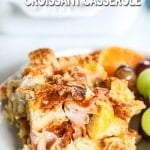 Ham & Cheese Croissant Breakfast Casserole on white plate with fresh grapes
