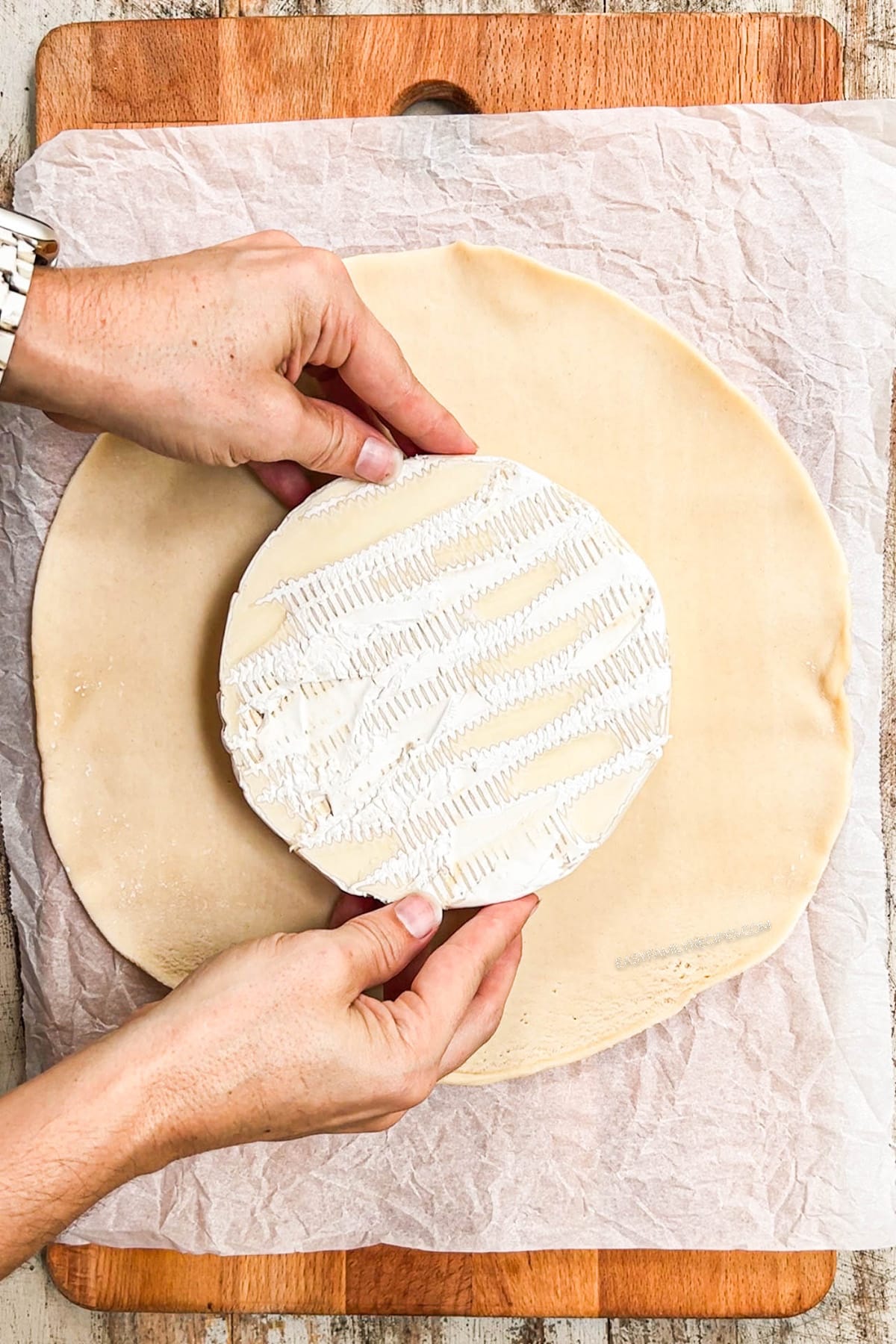 baked brie step 1 - roll out pie crust and lay brie on top