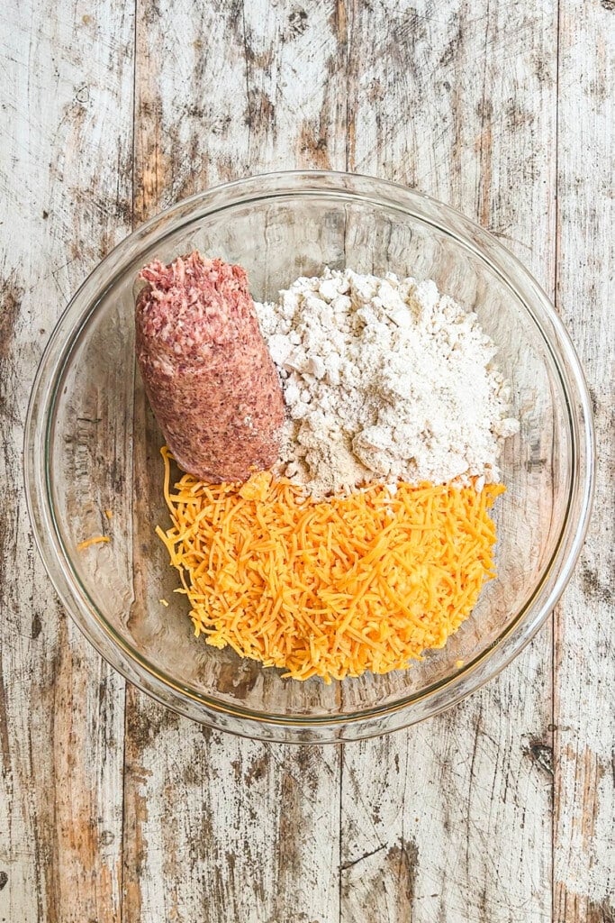 How to make cheddar bay sausage balls step 1: Add cheddar cheese, biscuit mix, and sausage to a mixing bowl.