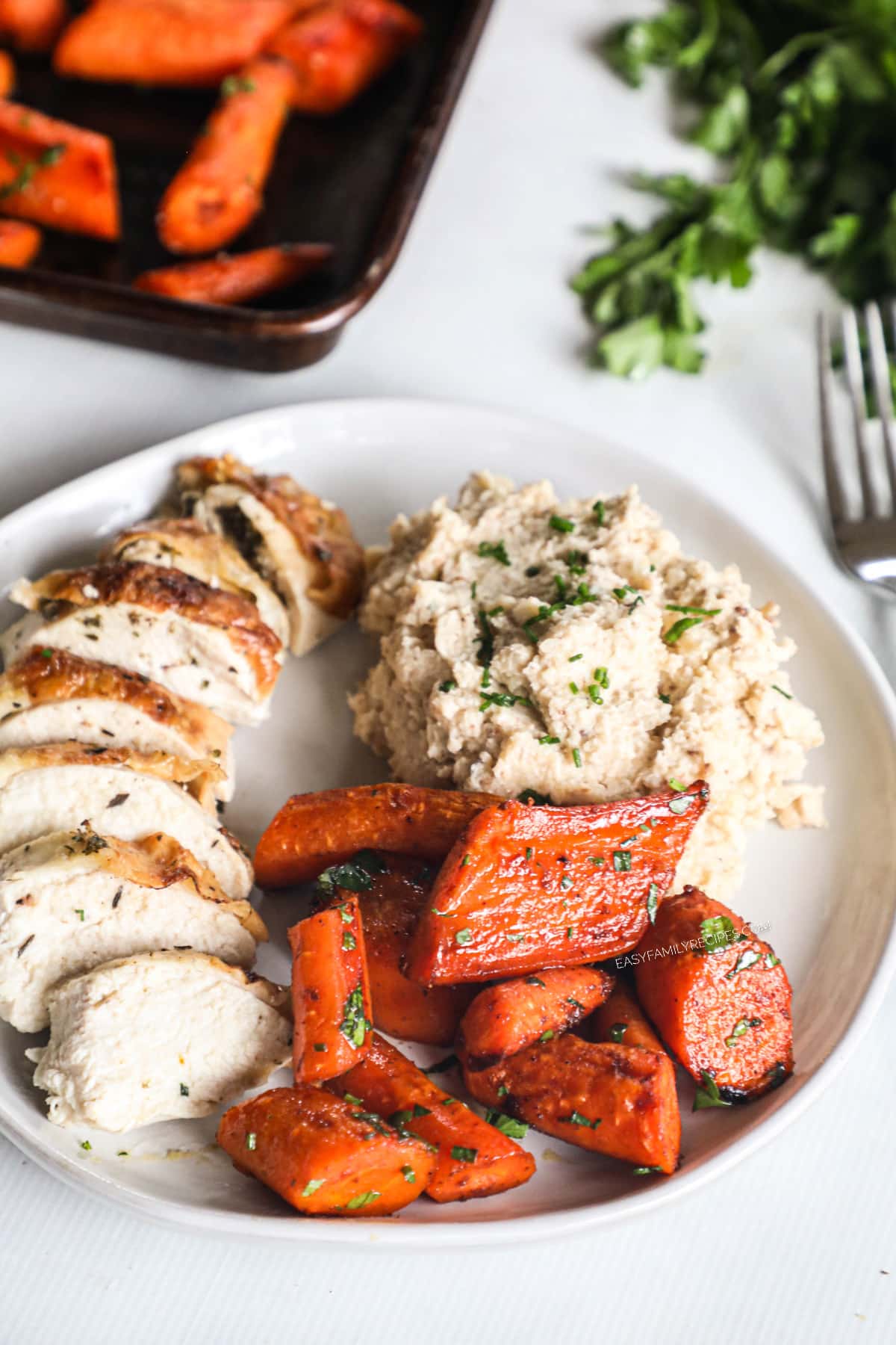 Tender maple glazed carrots on plate with mashed potatoes and pork