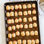 Overhead view of mini pigs in a blanket lined up on sheet pan